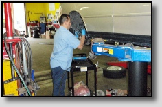 Mechanic Working on Wheel at Precise Auto Service